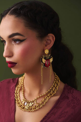 Woman wearing gold jewelry with a dark background